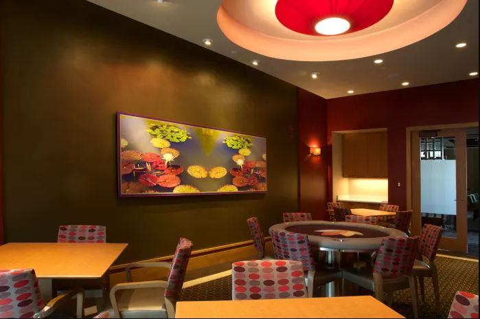 A modern restaurant interior featuring colorful wall art and cozy seating arrangements.