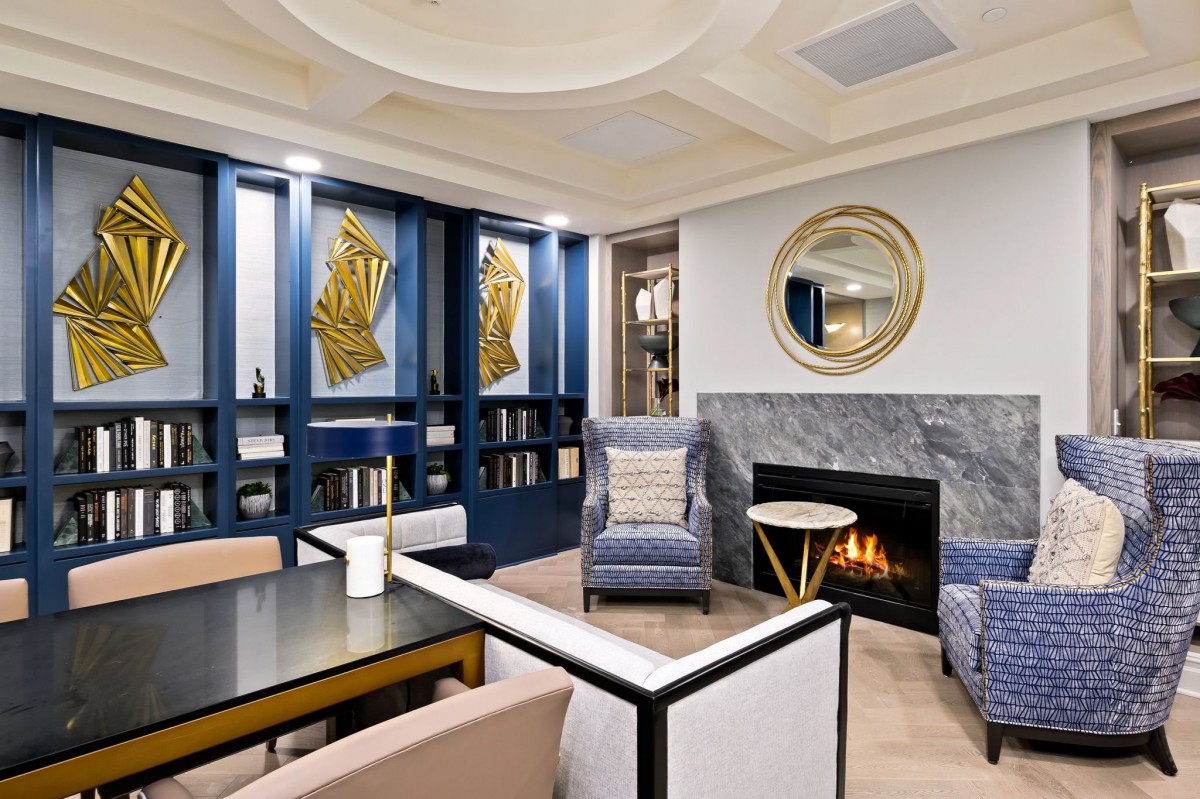 A stylish living room with modern decor, featuring a cozy fireplace, elegant artwork, and comfortable seating.