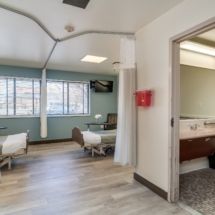 A clean and modern hospital room with two beds, featuring a spacious and well-lit interior.