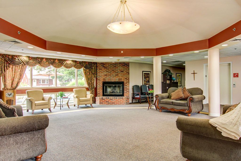 A spacious living room with a fireplace, sofas, and large windows.