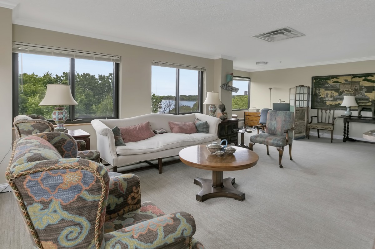 A well-lit living room with a comfortable sofa, coffee table, and large windows.