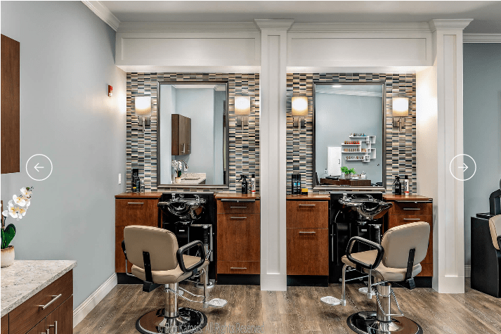 A modern barbershop interior with two styling stations featuring mirrors and chairs.