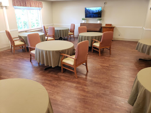 A spacious dining area featuring round tables and comfortable chairs, designed for communal gatherings.