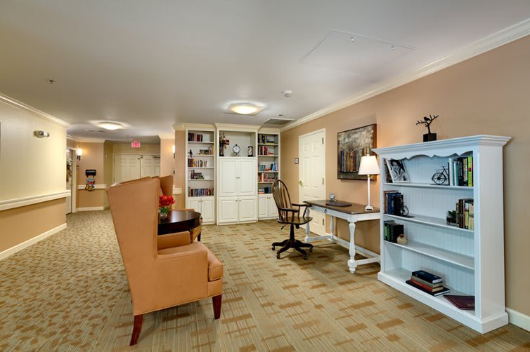 A cozy office space with a desk, chair, and bookshelf.