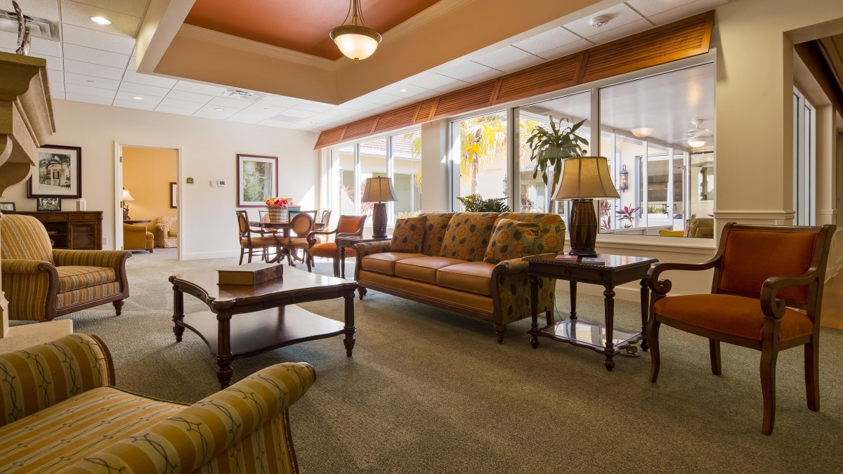 A cozy living room with comfortable seating, tables, and ample natural light.