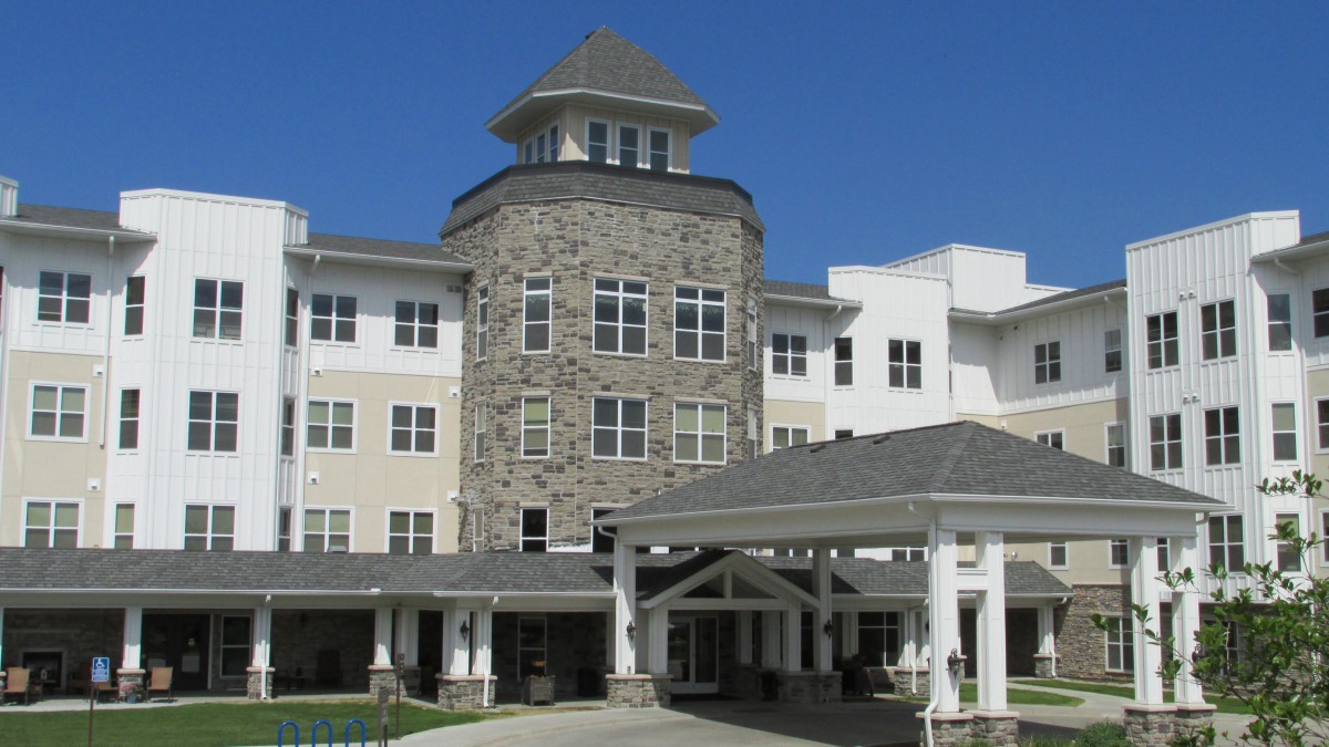 A three-story building with a stone facade and covered entrance.