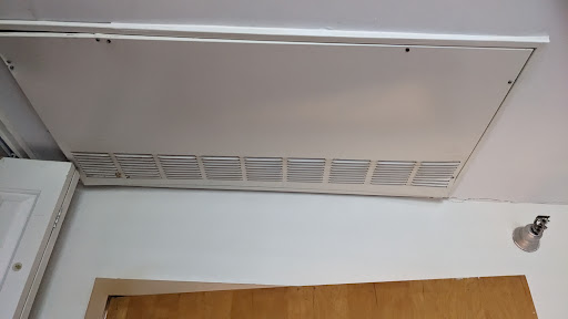 A close-up view of a white air vent in an indoor setting.