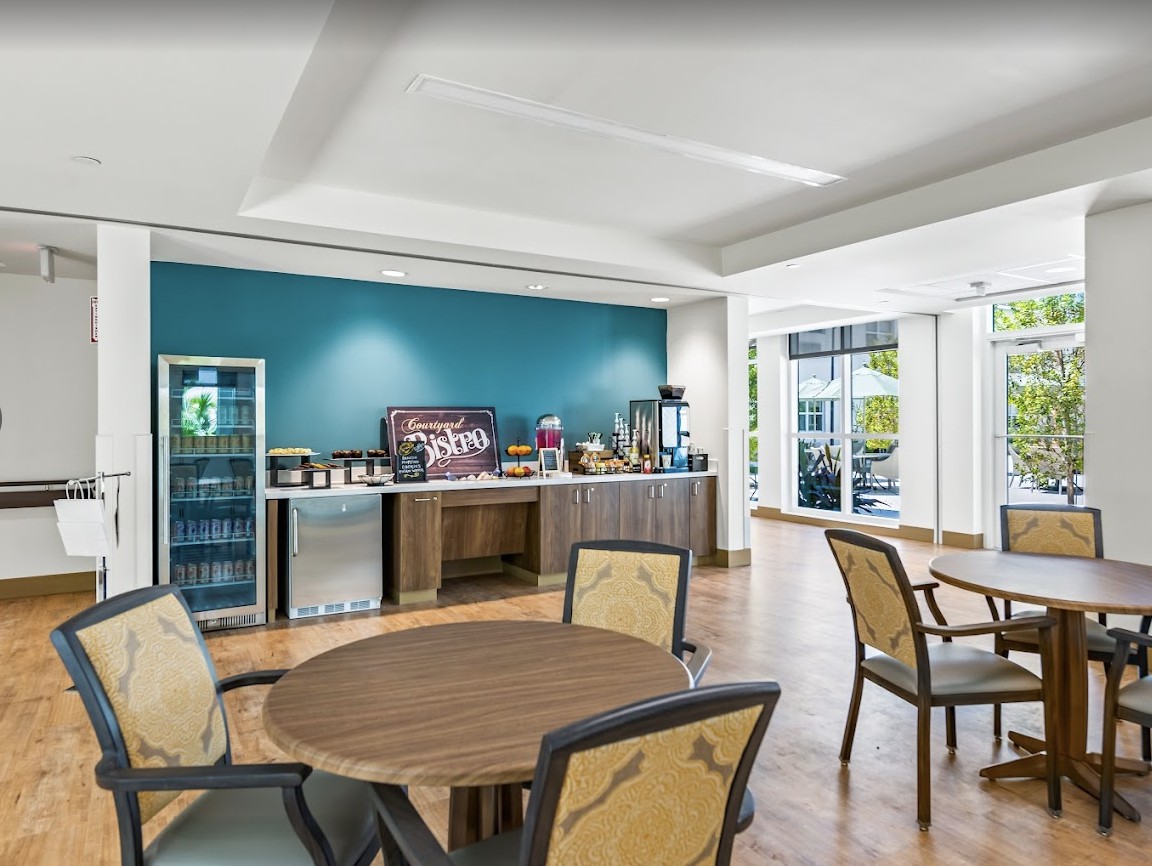 A modern cafe interior with a beverage station and seating area.