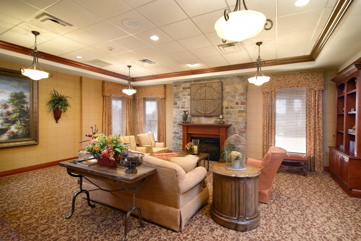A cozy living room with a fireplace, comfortable seating, and elegant lighting.