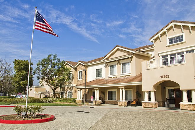 A suburban residential building with an American flag waving under a clear blue sky.