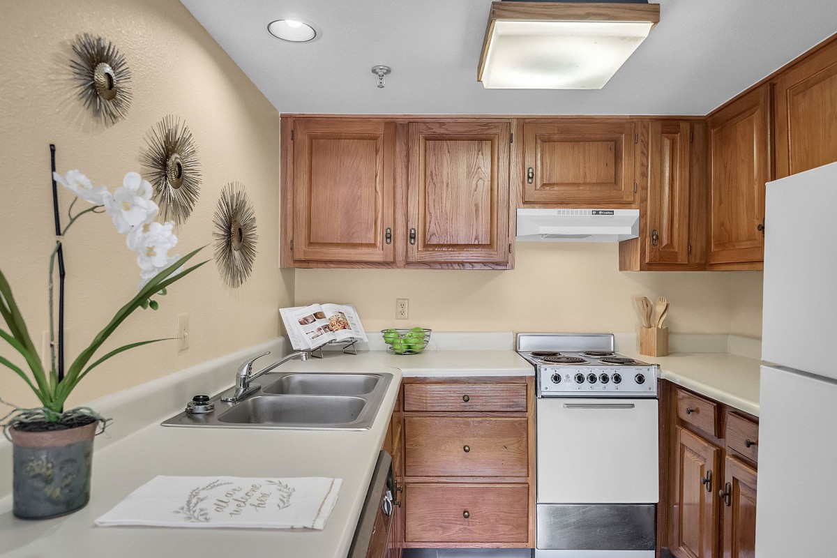 A cozy kitchen with wooden cabinets and a compact stove.