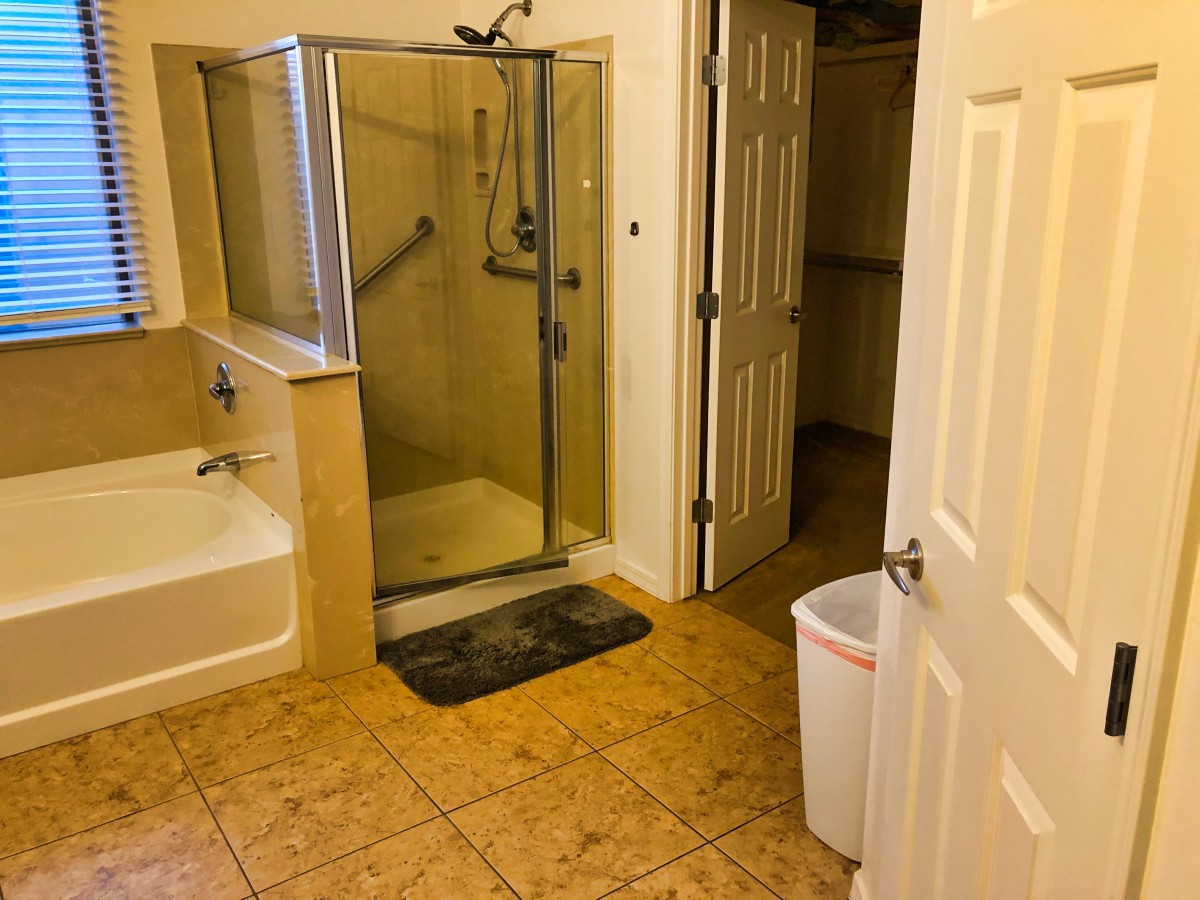 A bathroom featuring a glass shower, bathtub, and tile flooring.