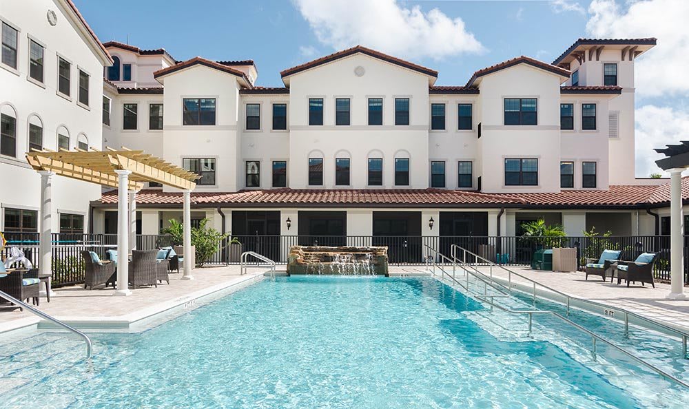 A residential building with a swimming pool in front, showcasing modern architecture and outdoor leisure space.