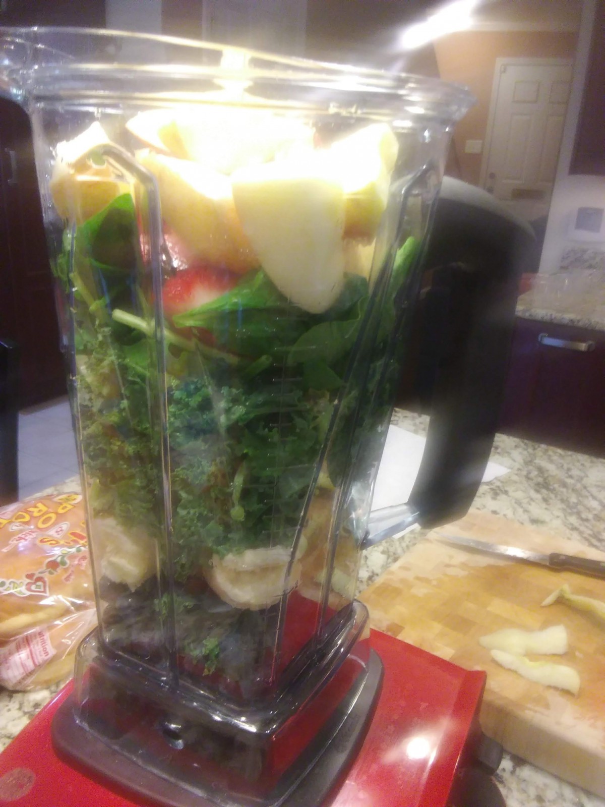 A blender filled with fresh fruits and vegetables ready to be blended into a smoothie.