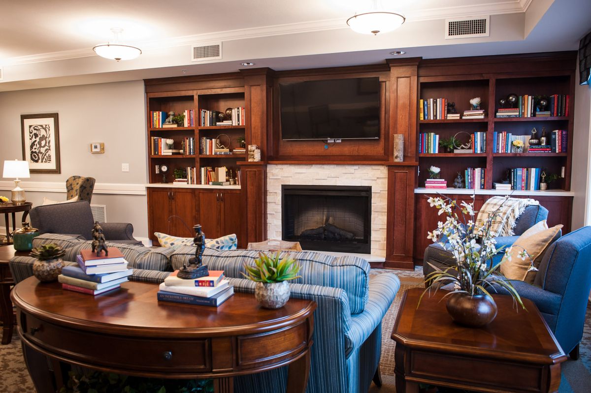 A cozy living room featuring a fireplace, built-in bookshelves, and comfortable seating.