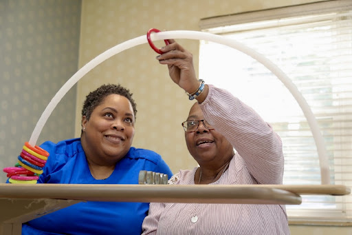 Two women engaged in a cooperative activity, fostering connection and support.