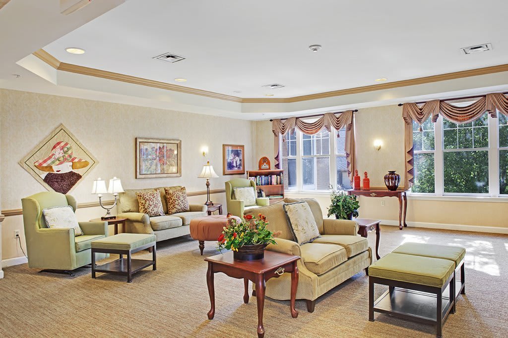 A spacious and elegantly decorated living room with various seating arrangements and warm lighting.