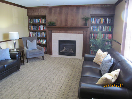 A cozy living room featuring a fireplace, bookshelves filled with books, and comfortable seating.