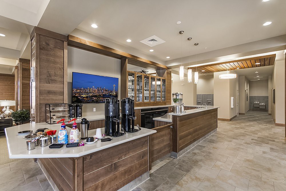 A modern cafe with a well-lit coffee station and wooden accents.