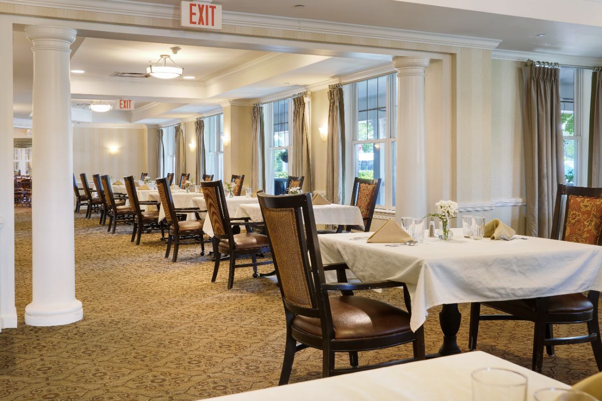 Elegant dining room with neatly set tables and chairs.