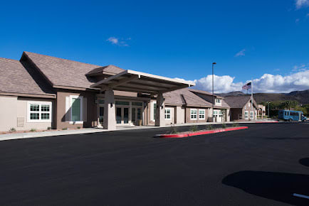 A modern building with a wide entrance and clear blue sky above.