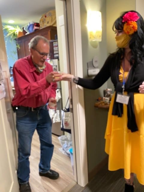 A man and woman exchange a handshake in an indoor setting near a doorway.