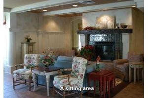 A cozy sitting area with floral chairs and a fireplace.