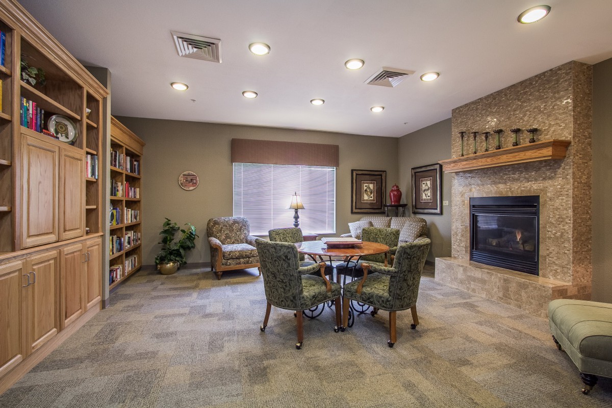 A cozy living room with a fireplace, bookshelves, and comfortable seating.