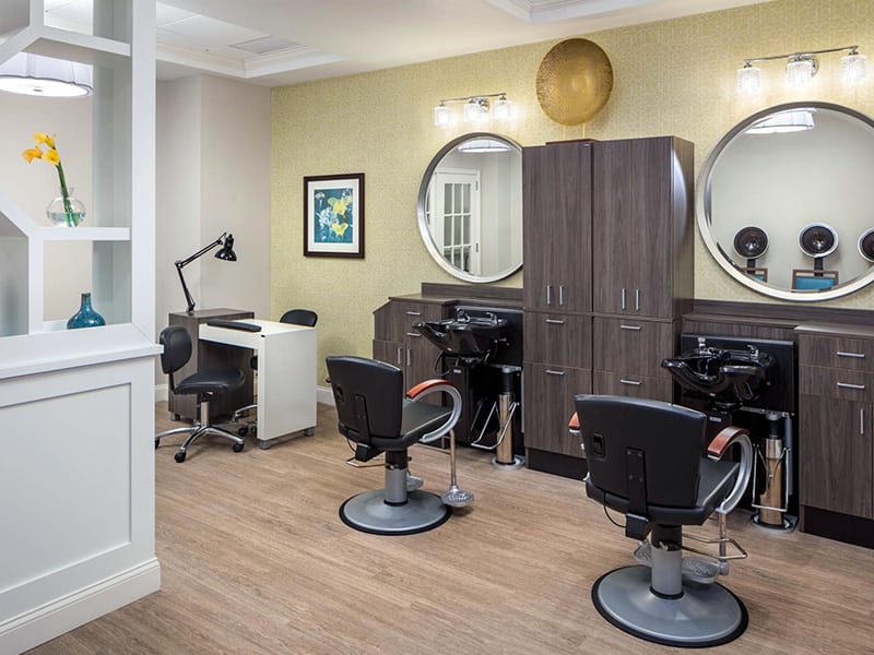 A modern hair salon with stylish workstations and comfortable seating.