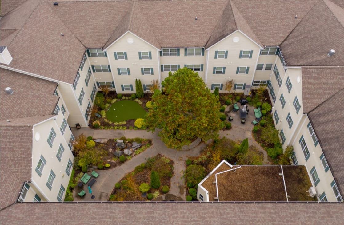 Aerial view of a building with a landscaped courtyard featuring trees and pathways.