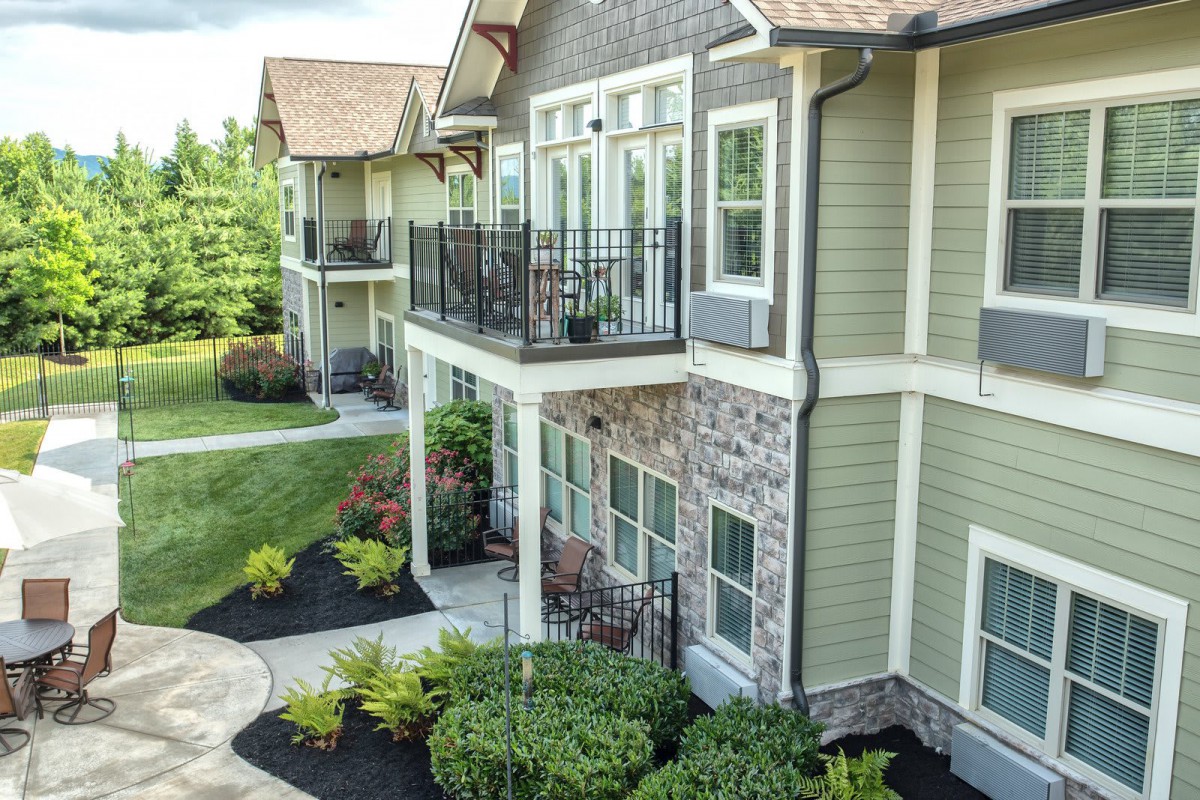 Modern apartment complex with landscaped surroundings and private balconies.