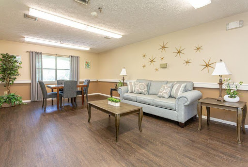 A cozy living room setup featuring a light blue sofa, wooden coffee table, and dining area.