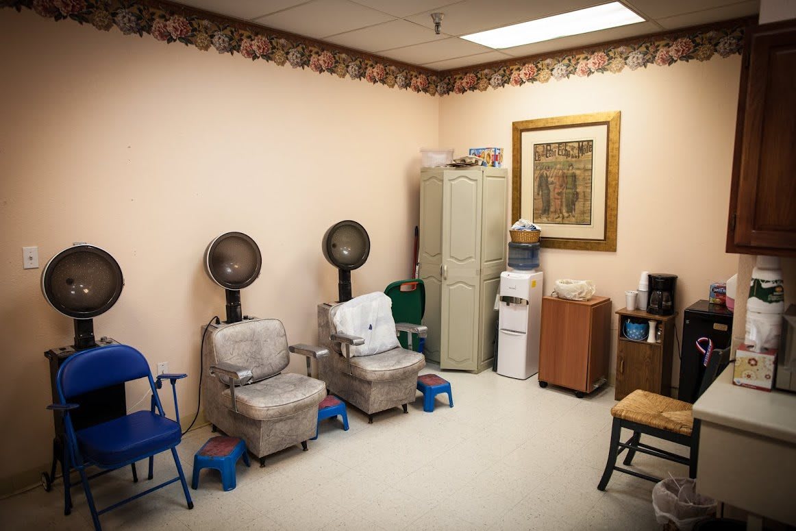 A quaint salon space featuring vintage hair dryers and comfortable seating.
