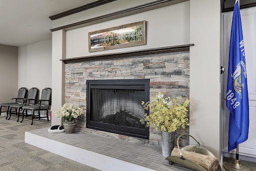 A beautifully designed living room featuring a modern fireplace with a stone surround, complemented by artwork and decorative flowers.