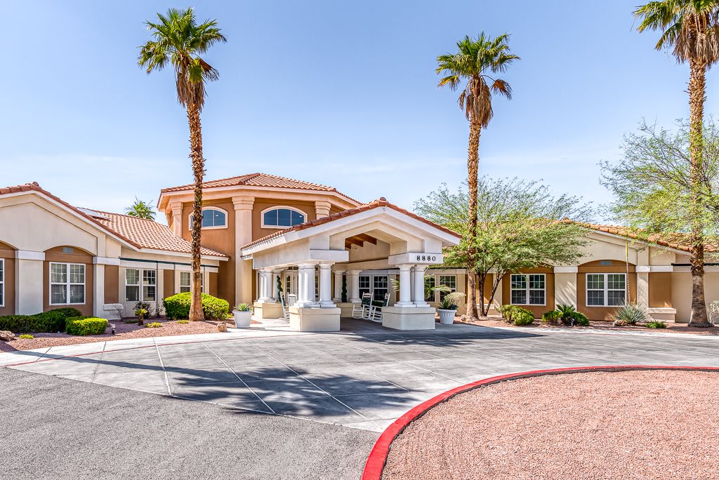 A sunny day at the entrance of a stylish building surrounded by palm trees.