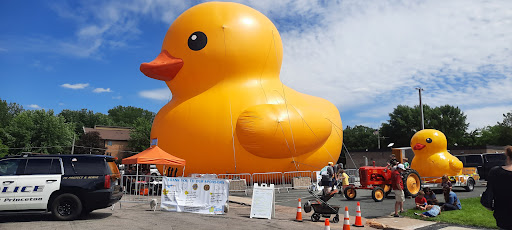 A giant inflatable rubber duck displayed at an outdoor event, attracting the attention of visitors.