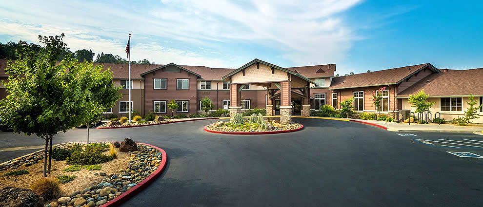 A residential building with a landscaped entrance and circular driveway.