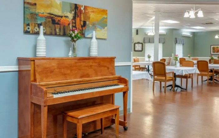 A cozy interior with a wooden piano and a dining area in the background.