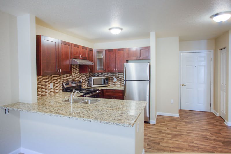 A modern kitchen featuring granite countertops and stainless steel appliances.