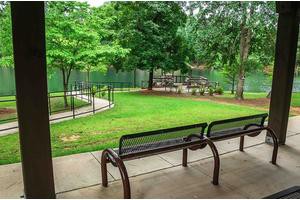 A peaceful park area with benches, greenery, and a winding pathway.