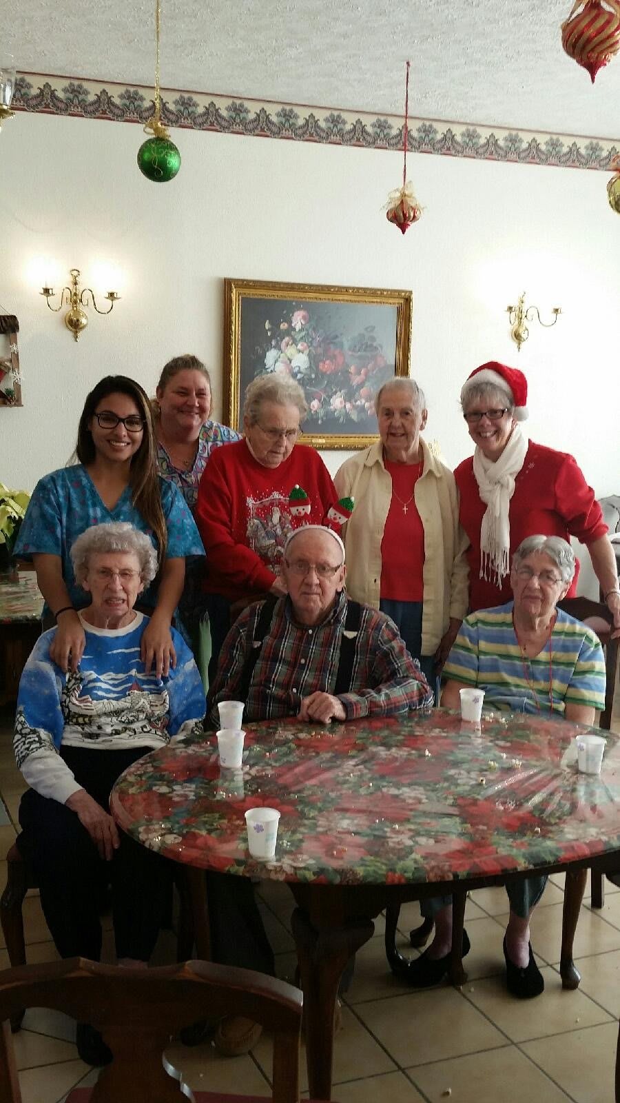 A group of people gathered around a table, celebrating the holiday season.