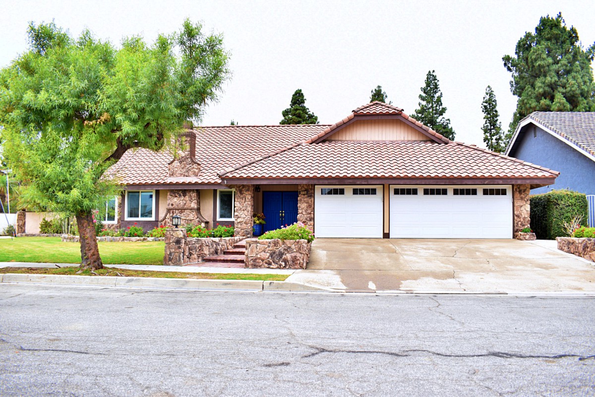 A suburban house with a stone facade and a three-car garage.