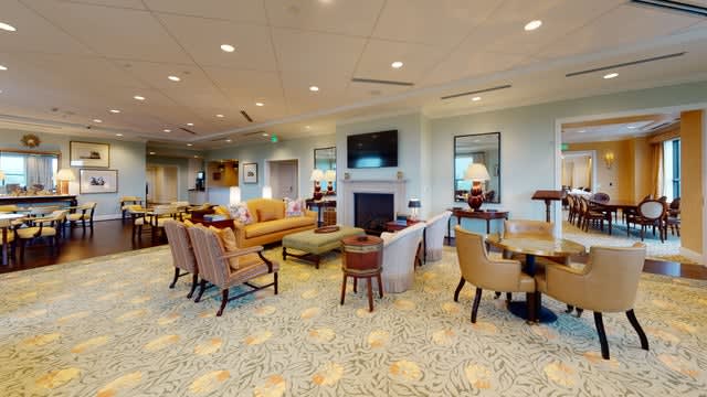 A spacious and well-furnished living room with comfortable seating, a fireplace, and a television.