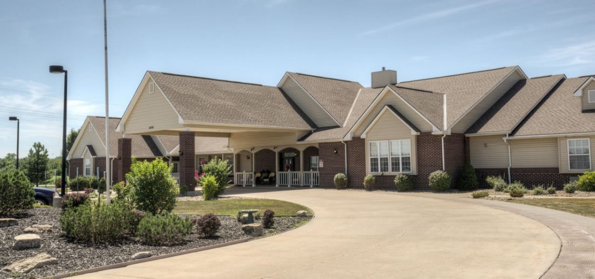 A suburban house with a spacious driveway and landscaped front yard.