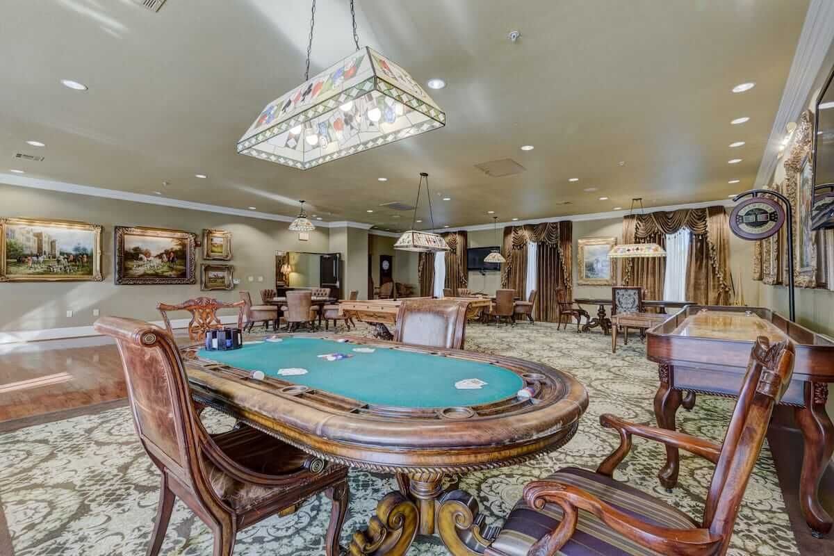 A luxurious casino poker room with ornate furniture and elegant chandeliers.