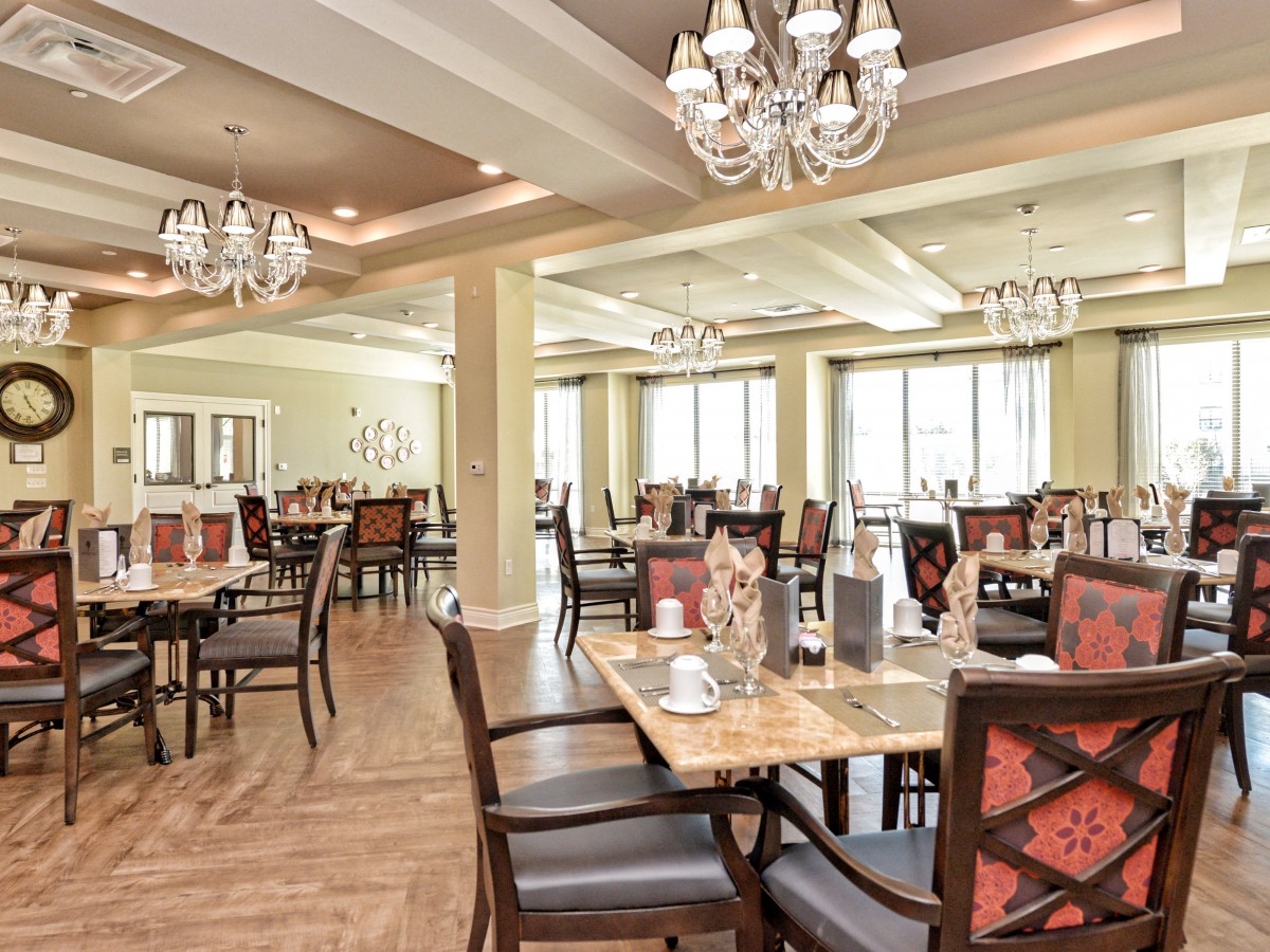Elegant dining room interior with chandeliers and well-arranged tables.