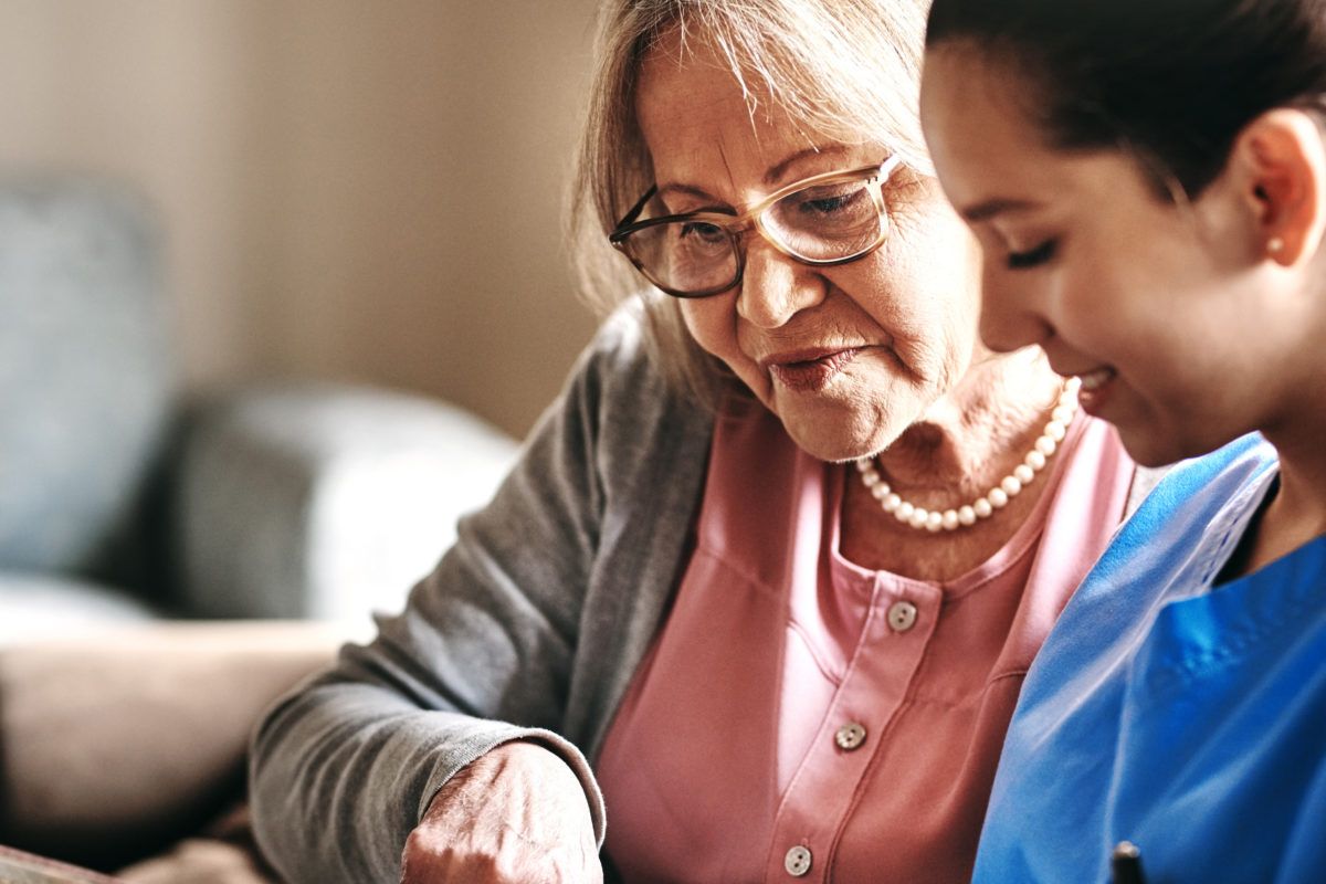 An elderly woman receiving care and companionship from a caregiver.
