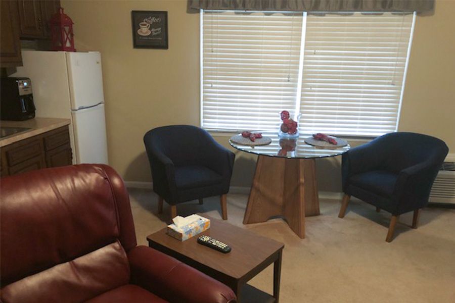 Cozy living room with a small dining area and refrigerator.