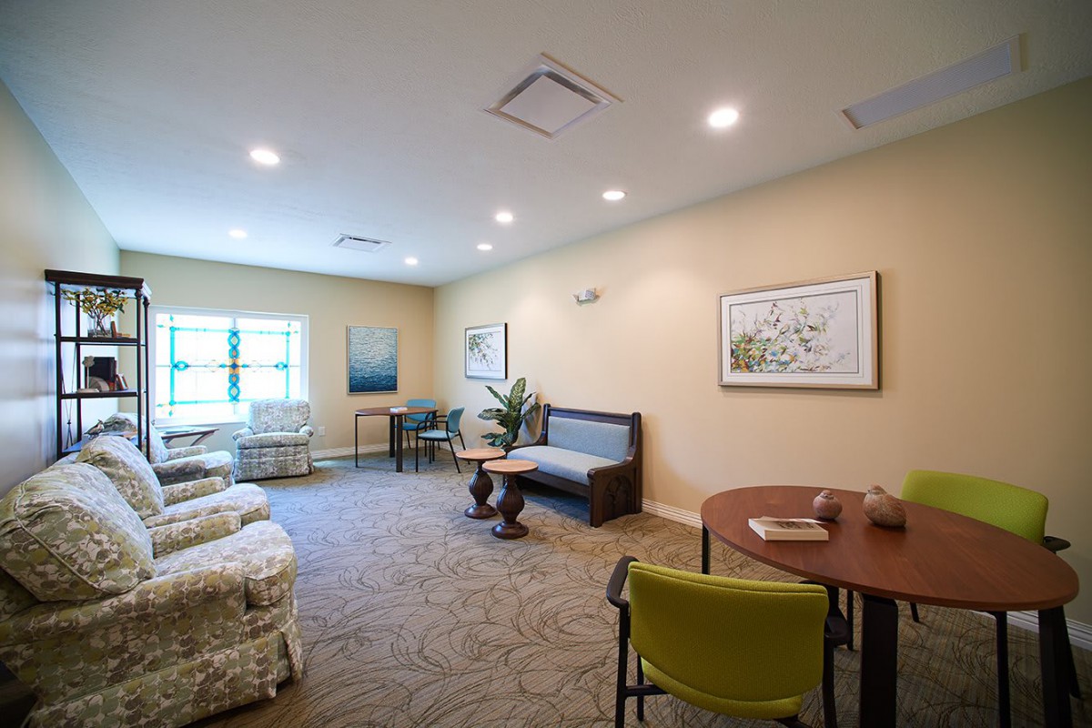 A cozy living room with comfortable seating, artwork on the walls, and a warm atmosphere.