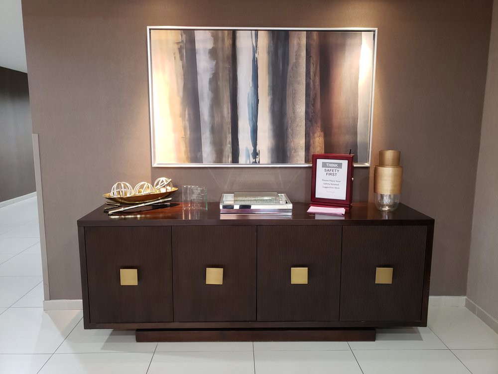 A modern sideboard with decorative items and abstract artwork on the wall.